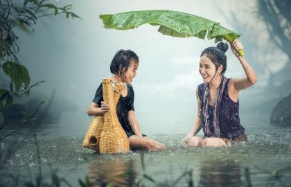 母女二人美女妈妈手持大芭蕉叶为女儿挡雨