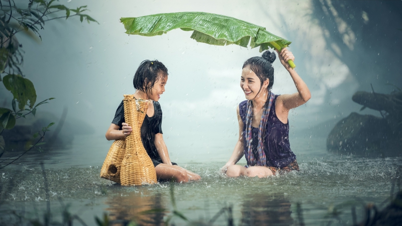 母女二人美女妈妈手持大芭蕉叶为女儿挡雨