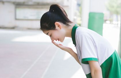 校花美女身穿校服低头手摸鼻子笑容甜美