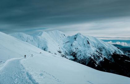 雪山顶的探险团队,浩瀚的天空下白皑皑的雪山