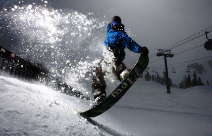 身穿蓝色冲锋衣的男人在滑雪动作非常帅雪花纷飞