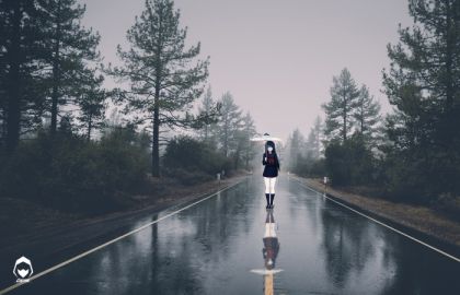 野外的笔直大路上站着一个打伞的可爱女孩雪白的长腿高筒的黑靴子两旁的大树在雨中格外漂亮